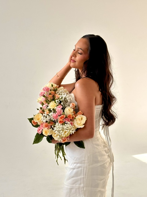 Bride holding a bouquet with soft glam makeup and an elegant bridal look.